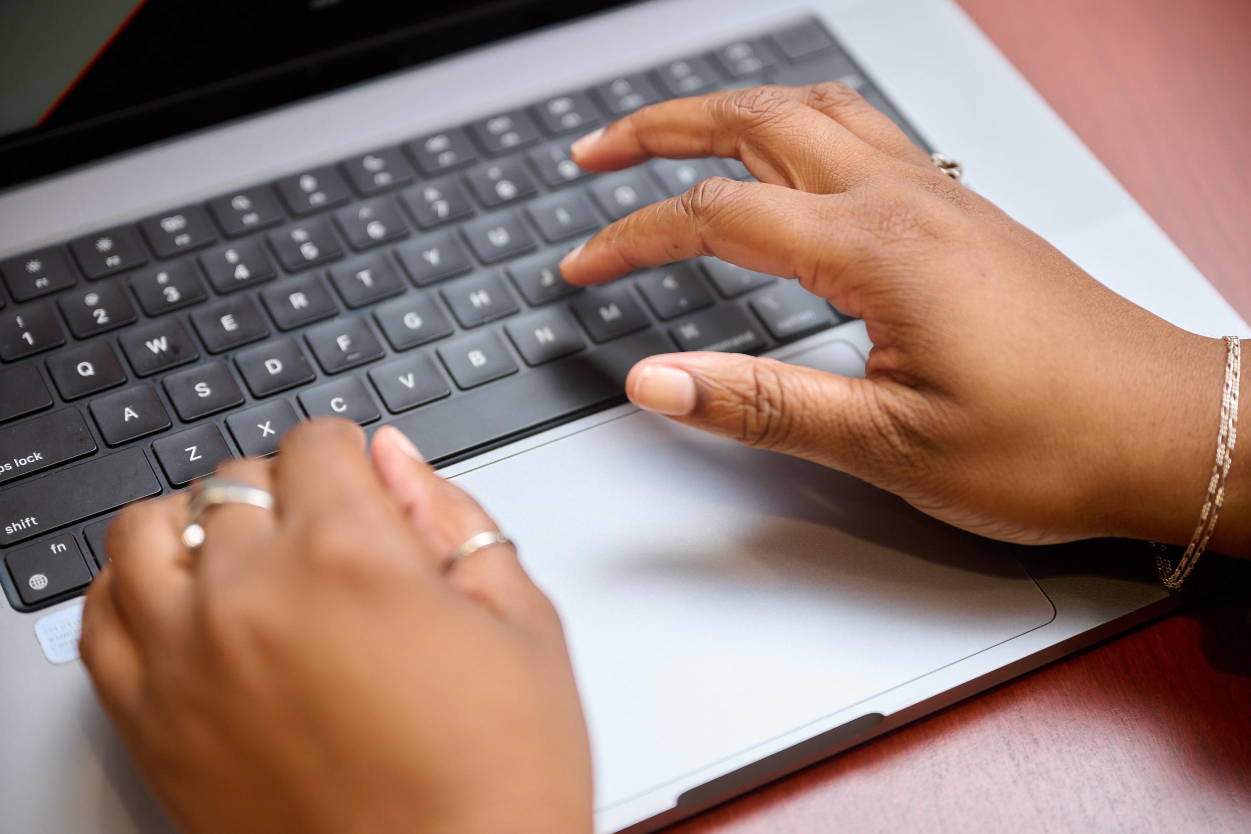 Hands typing on a computer